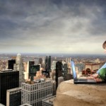 child with laptop on building high above New York City skyline